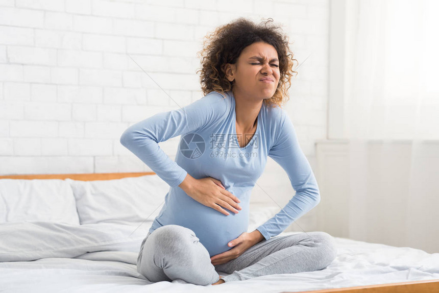 宫缩孕妇腹部疼痛坐在床上准备分娩图片