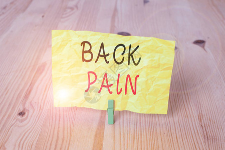 概念手写显示背痛概念意义身体下背部感觉骨头酸痛木地板背景绿色衣图片