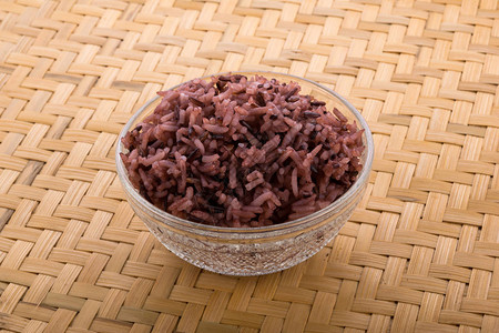 木制背景上的碗里的米饭图片