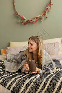 床上的漂亮女人在一格子饮料茶下现代和时图片