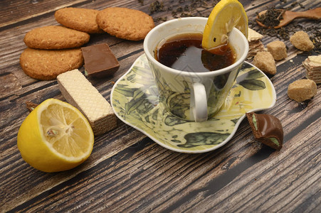 一杯黑茶切柠檬棕色糖片燕麦饼干木图片