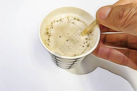 紧闭瞬间咖啡牛奶和木勺子在白图片