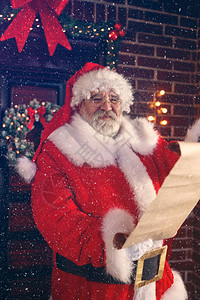 微笑的圣诞老人阅读儿童希望圣诞礼物清单a图片