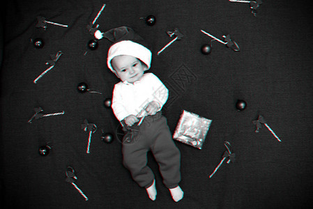 圣诞老人帽子中快乐的婴儿男孩在圣诞糖果甘蔗红球和礼品盒中微笑3D虚拟图片