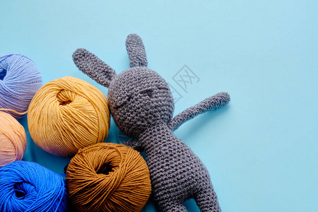 蓝色背景的灰色小有亮色线纹胸毛Amigurumi玩具制造手工制作编织图片