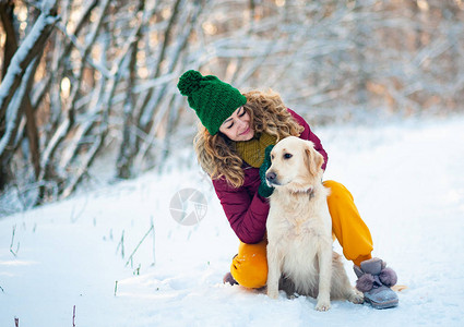 微笑的女人抱着她的宠物狗金毛猎犬靠近脸图片