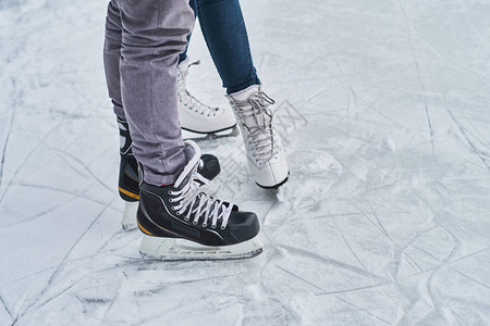 可爱的小情侣在户外溜冰场滑冰近图片