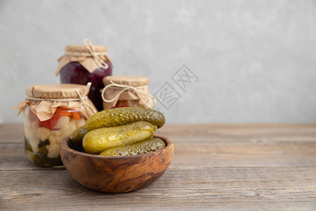 腌制发酵的黄瓜放在木桌上的木碗里在乌贼背景罐头与冬天的空白罐头蔬菜图片