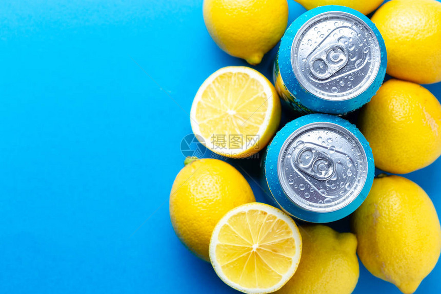 蓝色背景上有冷凝水滴和柠檬的汽水罐图片