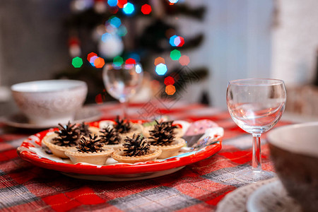 传统装饰的圣诞餐桌散景灯背景上盘子上的节日餐桌锥的创意装饰庆图片