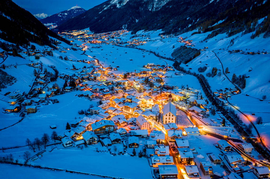 奥地利城镇Neustift的冬季夜间城市风景市中心和教堂的空中观察房屋夜照和交通灯光图片