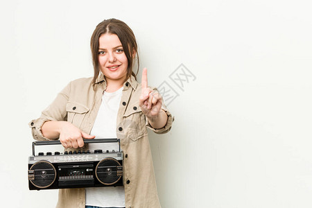 年轻的卷发女人拿着复古收音机图片