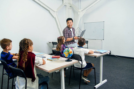 白种人学童在学校上课时听韩国老师讲课的背影有趣的教育和图片