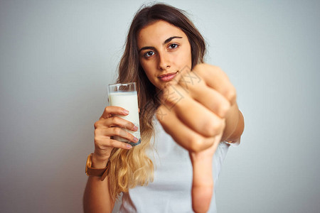 年轻美女在白色孤立背景上喝杯牛奶图片