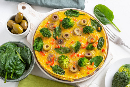 盘子上有花椰菜菠菜和橄榄的煎蛋卷图片