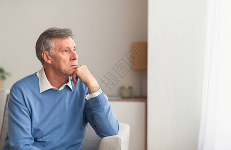 退休和萧条高贵的绅士们在家中沙发上仰望着窗外有选择的图片