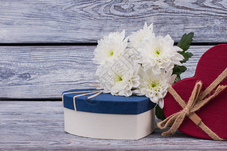情人节背景与鲜花和礼物新鲜的白菊花和心形礼盒图片