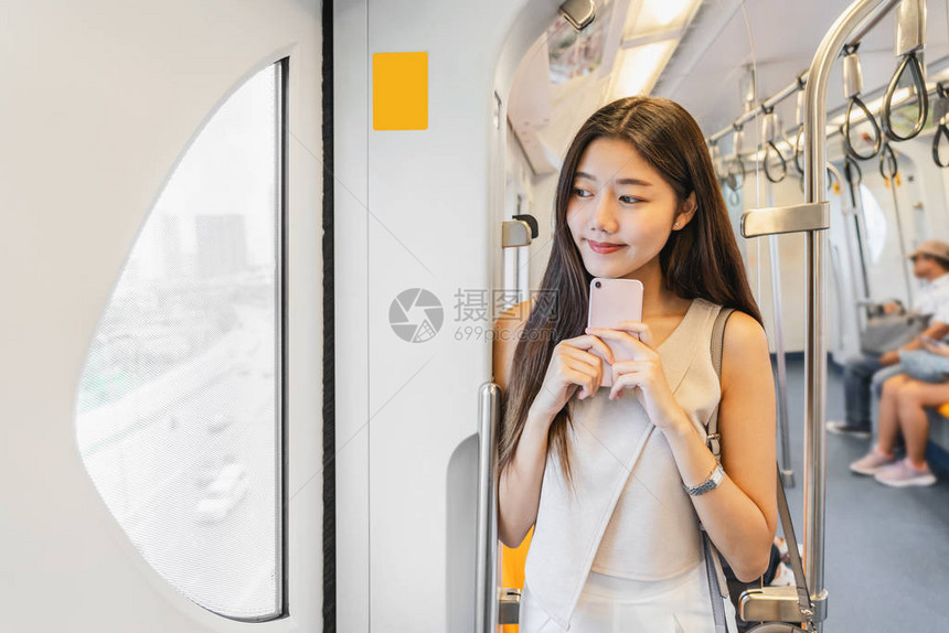 亚洲年轻女乘客在大城市旅行时通过智能手机在地铁列车上使用社交网络日本韩国的生活方式和日常生活通图片