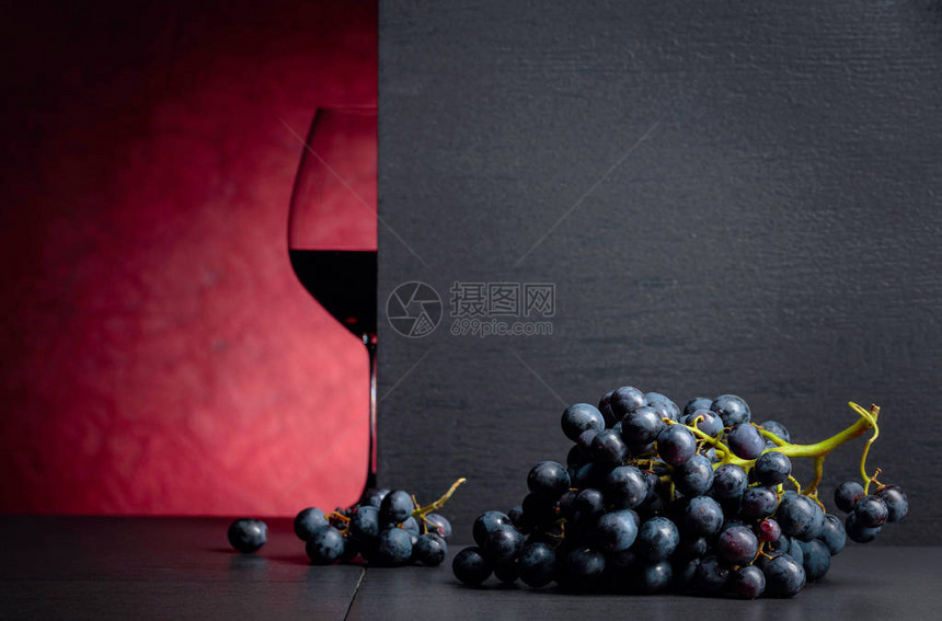 红葡萄在黑桌和杯红酒上您的文本空闲间图片