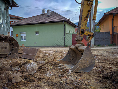 推土机挖掘机铲头在泥泞肮脏的黄色挖掘机挖掘现场工作图片