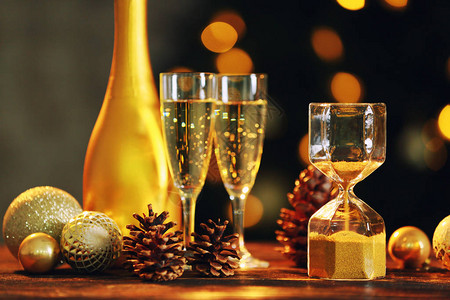 玻璃杯圣诞装饰品和香槟放在桌子上对图片