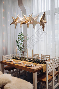 美丽的圣诞餐桌与蜡烛和枞树装饰在舒适的现代室内特写庆祝12月假期新年图片