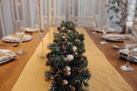 美丽的圣诞餐桌与蜡烛和枞树装饰在舒适的现代室内特写庆祝12月假期新年图片