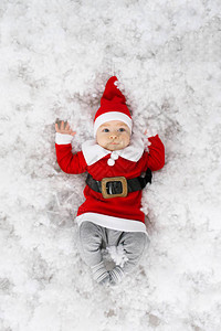 圣诞老人服装里有趣的小孩躺在人造图片