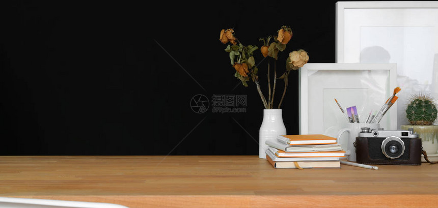 在木桌和黑墙背景上用办公用品和复印空间近距离观察图片