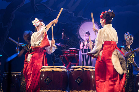 日本传统表演舞台上的白人和红色和服以及狐狸面具鼓里的女演员们聚在舞台图片