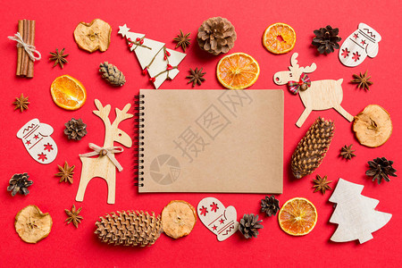 顶尖的笔记本装饰着喜剧玩具和圣诞标志的红色背景驯鹿和新年图片