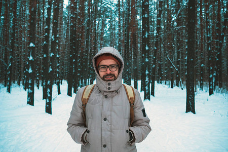 穿着冬装的年轻人站在冬天白雪皑的森林中间图片