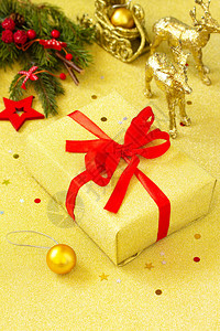 圣诞礼物盒配有红丝带和树枝装饰品的金盒图片