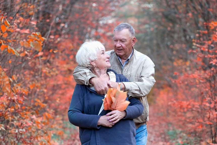 快乐的老年夫妇拥抱和在秋图片