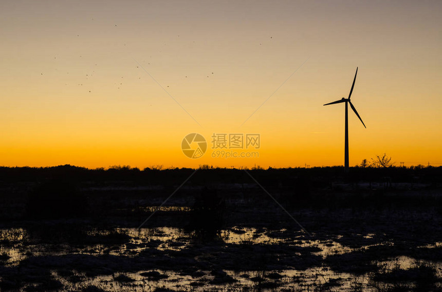 日落风力涡轮机和飞图片