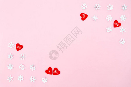 情人节背景红色的心和粉红色背景上的雪花情人节的概念平躺顶视图片