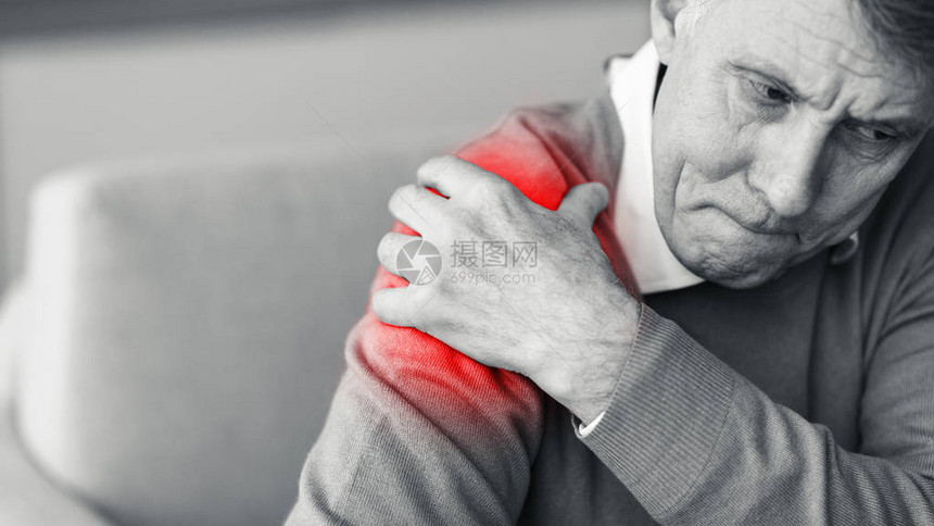 老年人触摸着红色痛苦带的肩膀图片