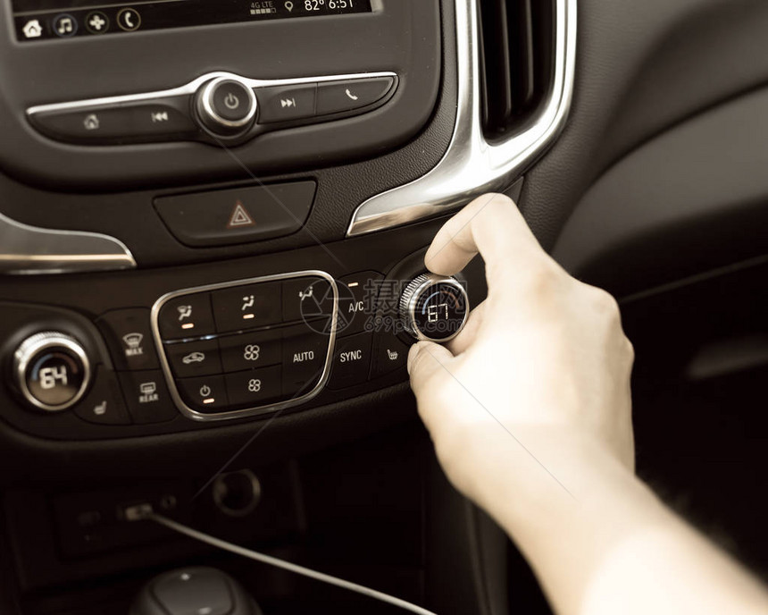 现代汽车冷却温度上的复古色调右手旋钮调节到67华氏度亚洲男手在仪图片