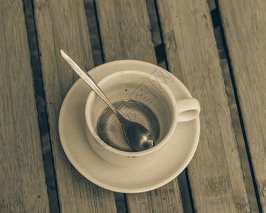 越南传统牛奶咖啡空杯子放在户外木制桌边图片