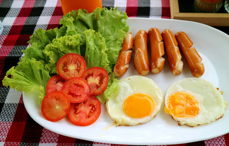 一盘煎鸡蛋和炸香肠配新鲜沙拉早餐图片