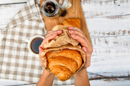 羊角面包在手中鲜美羊角面包在手中的特写镜头在平坦的背景包图片