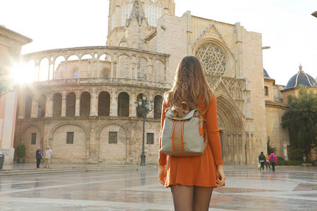 在阳光明媚的日子里参观瓦伦西亚大教堂的漂亮女孩的背影图片