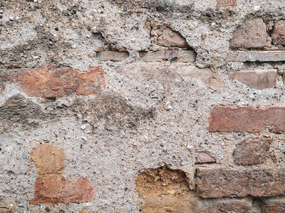 户外立面建筑的墙壁上用砖块砌成的旧石墙背景图片