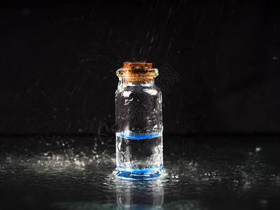 一瓶蓝色液体和黑色底的瓶子图片