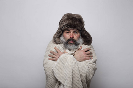 成年男子用毯子和帽子在寒冷中摇图片