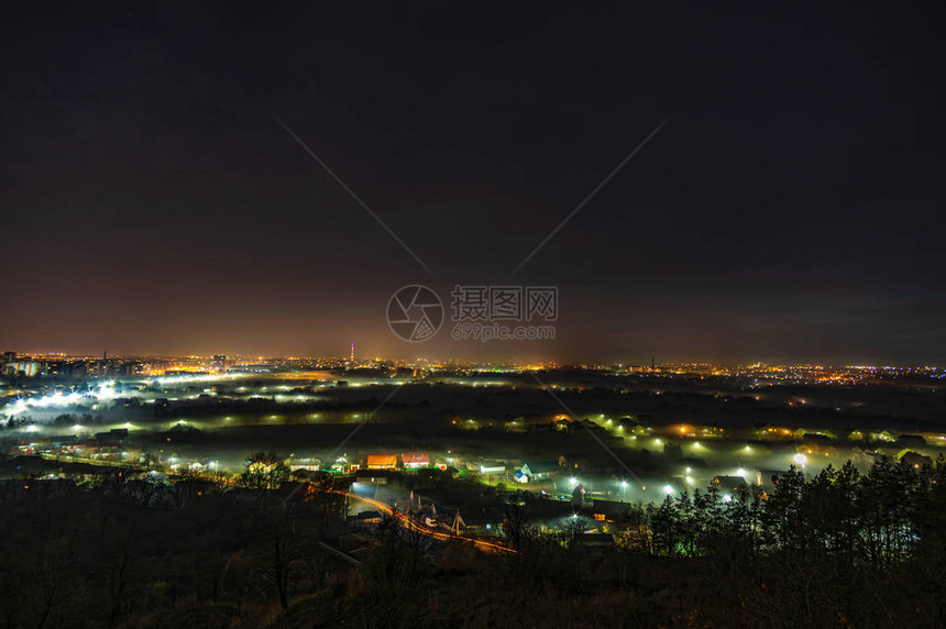 秋季山区雾中的城市夜光图片