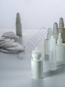 用于眼睛和鼻子的不同药物的滴管和喷雾剂以及化妆棉位于垂直背景上部分图片
