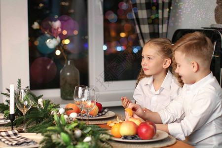 男孩和女孩庆祝新年喝果汁吃水果在新图片