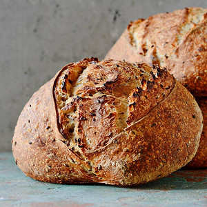 灰蓝色背景上由小麦和全麦面粉制成的自制新鲜出炉的乡村面包法国新图片
