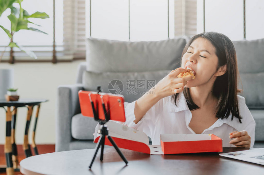 亚洲女美食博主一边吃披萨图片